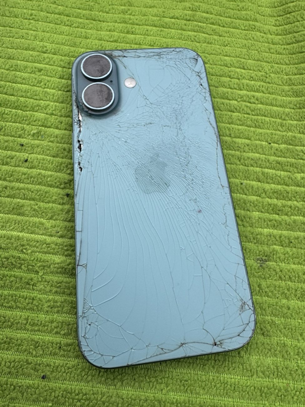 Blue iPhone 16 with shattered back glass before mobile repair in Erlton SW Calgary